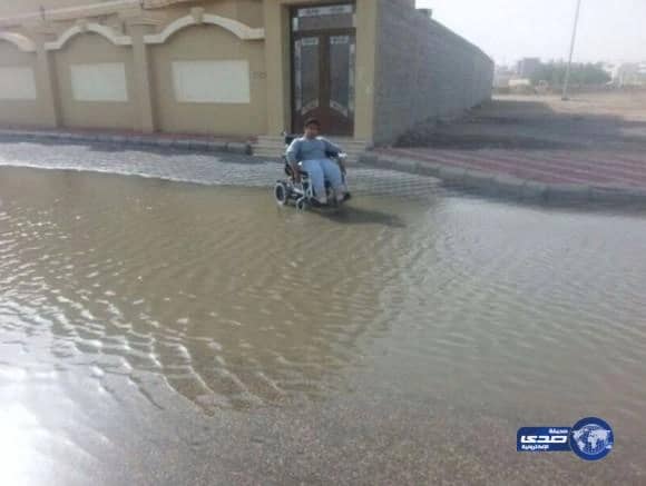 بالصور:معاق يعاني صعوبة الوصول إلى منزله بسبب تجمع مياه الأمطار