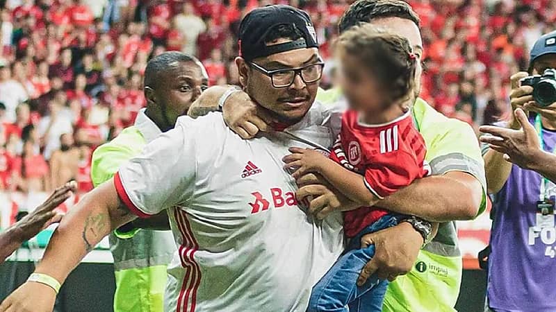 مشجع يقتحم ملعبا لضرب لاعب وهو يحمل طفلته